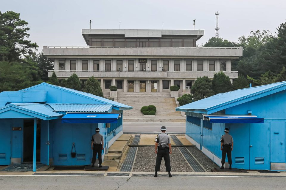 The military demarcation line between North and South Korea runs through the blue conference buildings at Panmunjom.