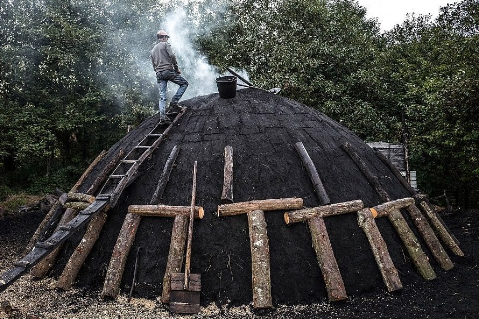 It is then covered with earth or turf and burned in a controlled way, strictly limiting oxygen.