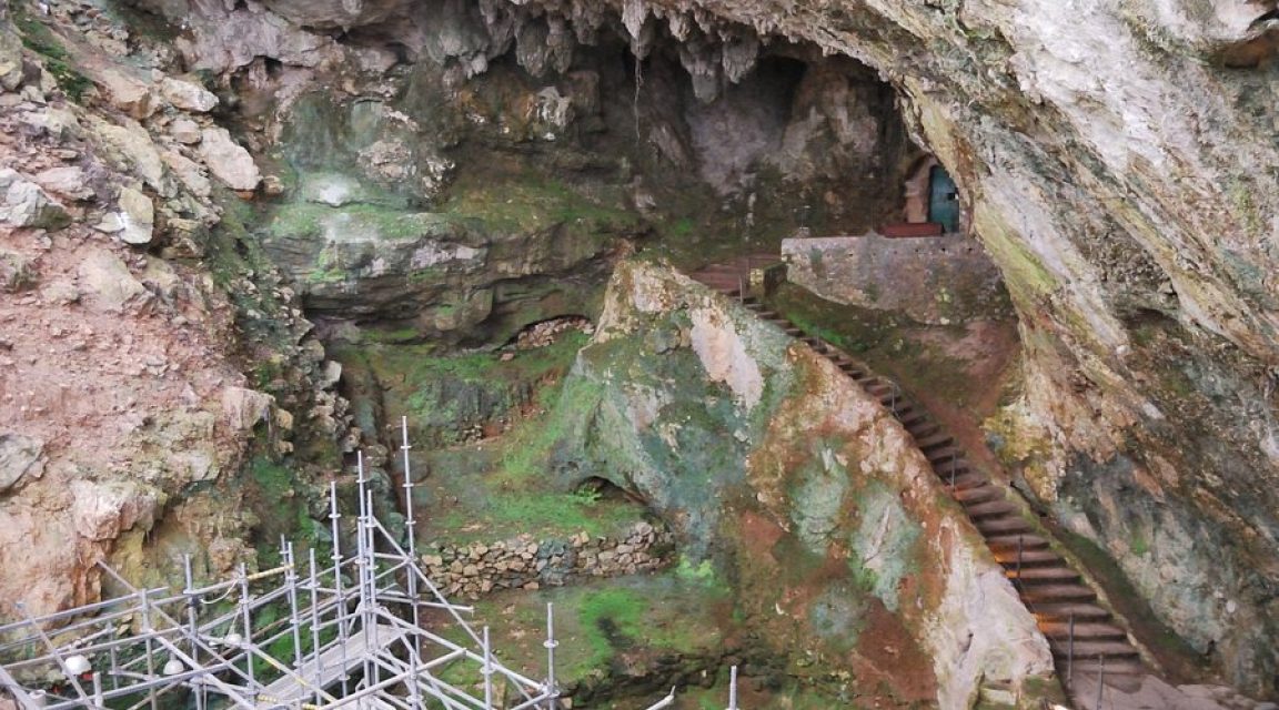 El Castillo Cave, Cantabria. Humans and Neanderthals have lived beneath this overhang for over 150,000 years. Today, the cave is entered through the doorway visible in the background.